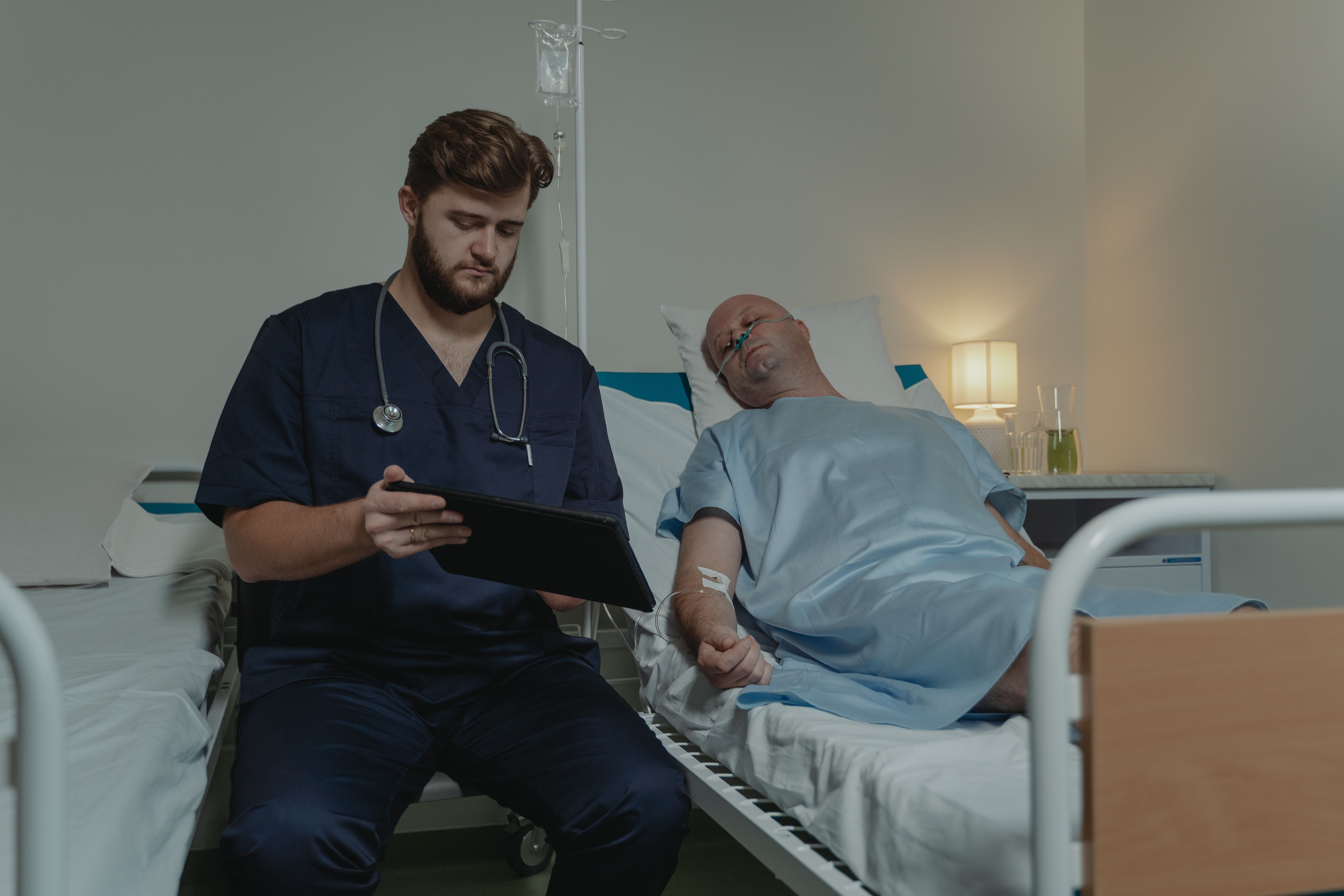 Nurse experiencing alarm fatigue while monitoring multiple patient screens in a hospital unit