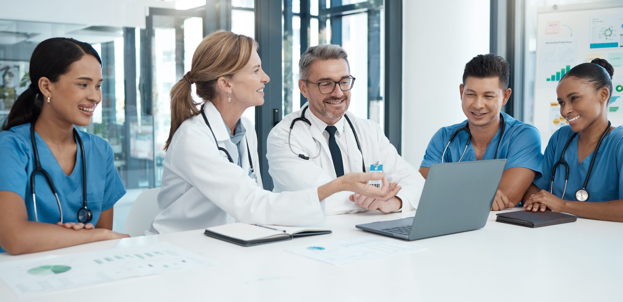 doctor-with-laptop-team-health-meeting-professional-collaboration-medical-innovation-healthcare-policy-teamwork-conference-room-diversity-group-discussion-clinic