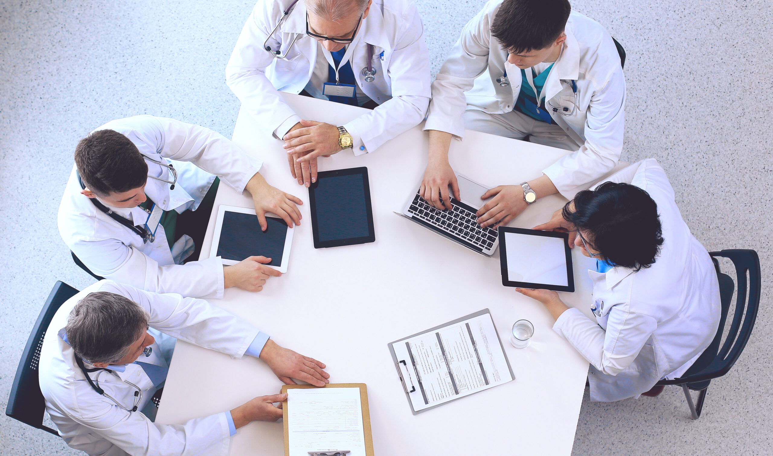 Medical team sitting and discussing at table, top view